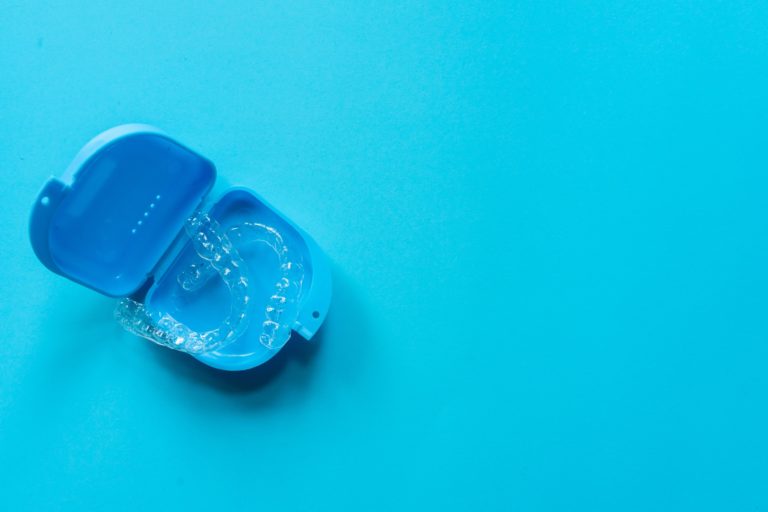 ClearCorrect clear aligners in a blue protective case on a blue background