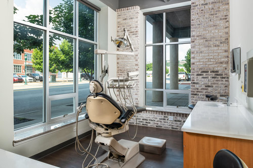 An exam room with a dental chair in the middle