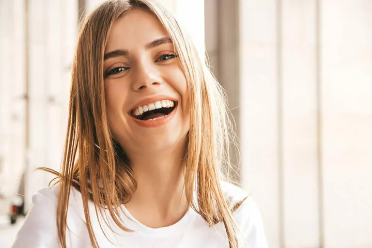 Stock image of a young blond woman smiling with her mouth open.